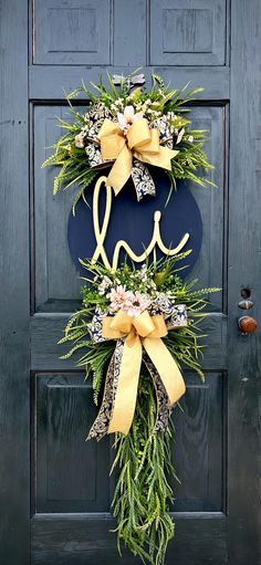 the front door is decorated with two wreaths and one has a monogram on it