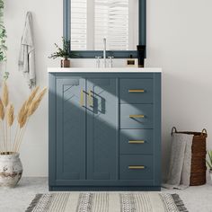 a bathroom with a blue cabinet, mirror and rug on the floor in front of it