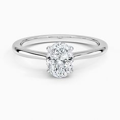 an oval shaped diamond ring with a thin band on the side, set in 18k white gold