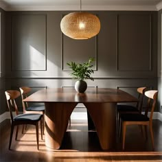 a dining room table with chairs and a vase on the table in front of it