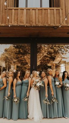 a group of women standing next to each other in front of a building with windows