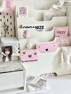 a white desk topped with lots of different types of cards and magnets on it