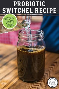 a jar filled with liquid sitting on top of a wooden table