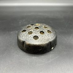 a metal object with holes in it sitting on a table