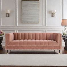 an elegant living room with pink velvet couches and white carpeted flooring in front of a large painting on the wall