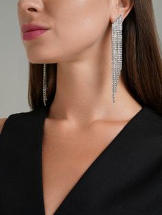 These earrings are striking, silver, and feature a cascading design. They are embellished with multiple rows of sparkling crystals, creating a dazzling effect that catches the light beautifully. The earrings taper towards the ends, giving them a sleek, elegant appearance. Perfect for adding a touch of glamour to any outfit, these earrings are ideal for special occasions or when you want to make a statement. Bolero Top, Shiny Earrings, Long Silver Earrings, Bolero Dress, Elegant Accessories, Sparkling Crystal, Earrings Silver, Long Earrings, Accessories Earrings