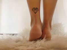 a woman's legs with a small heart tattoo on her left leg, and a diamond in the shape of a heart