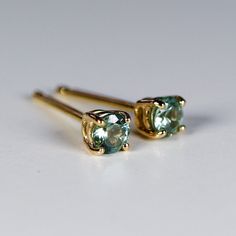 "14k yellow gold and 3mm calibrated Montana sapphire stud earrings. They will make a great companion to your beautiful wedding. They are very elegant for daily use or for official gatherings. SOLD AS PAIR. Available white gold or yellow gold from drop down menu. Material; 14k solid gold studs Round Montana Green sapphire 3mm. These are calibrated stones, so they are exactly 3mm. Prong settings. 14k gold backings included. ------------------------------------ GIFT WRAPPING My regular package is o 14k Gold Earrings With Tension Setting For Anniversary, 14k Gold Tension Setting Earrings For Anniversary, Fine Jewelry Earrings With Tension Setting For Gift, Yellow Gold Tension Setting Round Cut Earrings, Yellow Gold Round Cut Earrings With Tension Setting, Green Sapphire Earrings, Sapphire Jewelry Set, Green Montana, Sapphire Stud Earrings