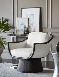 a white chair sitting on top of a wooden floor next to a potted plant