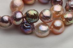 several different colored pearls on a white surface