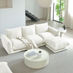 a white couch sitting on top of a floor next to a table