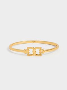 A sleek wrist accessory is a must-have in every stylish woman's jewellery collection. With a clean and minimal design, this bangle allows the interlocking Gabine design to take center stage and be the focal point of this standout piece. Complete in a polished gold-toned finish, this shiny cuff bangle will add a touch of high shine that does not overwhelm your outfit. Let it shine on its own, or create your own stunning stack with your other favourite bracelets. Edgy Rings, Earrings Edgy, Wrist Accessories, Let It Shine, Pretty Necklaces, Elegant Bracelet, Charles Keith, Shine On, Stunning Earrings