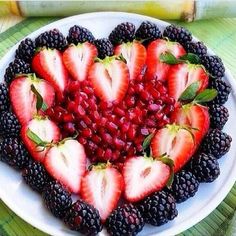 a heart shaped plate filled with berries and strawberries