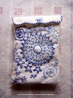 a piece of cloth with blue and white embroidery on it, sitting on top of a table