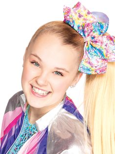 a girl with blonde hair wearing a colorful bow