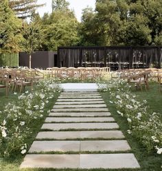 an outdoor ceremony setup with chairs and flowers