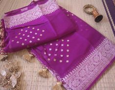 A Handwoven Purple Banarasi Georgette Kadhuwa Saree to make you stand out in a crowd. Furthermore, the saree is weaved all over with golden & silver zari in a beautiful kadhuwa weave pattern. Thus, this saree is for those who love handloom and have a taste for traditional attire. Also, it comes with blouse piece. Note: Banarasi Khaddi Georgete is a very soft and drapy fabric. Additional Information Color : Purple Zari Color: Golden and Silver Technique: Banarasi Kadhuwa Weaving Fabric: Pure Khad Purple Benaras Sarees, Purple Banarasi Saree, Purple Handloom Pre-draped Saree For Puja, Semi-stitched Purple Banarasi Silk Saree, Unstitched Purple Chinon Saree, Traditional Attire, Blouse Piece, Coin Purse, Hand Weaving