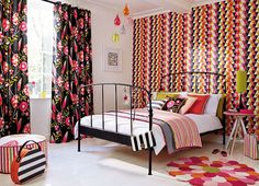 a bedroom decorated in bright colors and patterns