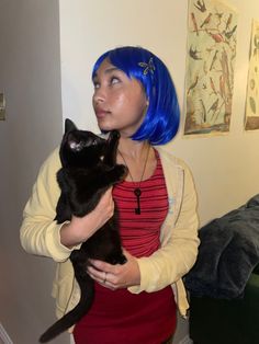 a woman with blue hair holding a black cat