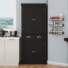 a tall black cabinet in a kitchen next to a stove top oven and countertop