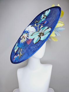 From the 2024 Featured Milliner of the Kentucky Derby Museum  Gorgeous Kentucky Derby hat fascinator  kentucky derby hat fascinator blue sinamay saucer with yellow and light blue feathers and blue blue white pink yellow embroidered flowers headband attachment.  each hat is totally one of a kind! no two are alike! *All hats are sold as displayed. No returns do to nature of product (headwear) Of course do not hesitate to contact me with any issues :) Check out my The Hat Doctor amazing news story Blue Feathered Fascinator For Spring, Spring Blue Feathered Fascinator, Whimsical Blue Mini Hats For Spring, Blue Whimsical Mini Hats For Spring, Flowers Headband, Derby Hats Fascinators, Blue Feathers, Hat Fascinator, Kentucky Derby Hat