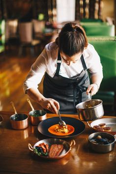 a woman in an apron preparing food on a table