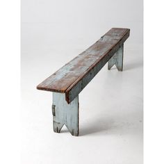 an old wooden bench sitting on top of a white floor