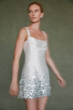 a woman in a white dress with silver sequins