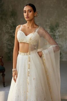 Ivory skirt with aari, sequin, thread embroidery in floral pattern. Paired with sleeveless embroidered padded blouse and dupatta. - Aza Fashions Festive Dresses With Sweetheart Neckline, White Bollywood Sleeveless Lehenga, White Sleeveless Bollywood Lehenga, White Bollywood Lehenga, Festive Sleeveless White Lehenga, Festive White Sleeveless Lehenga, White Embellished Sleeveless Set, Elegant Sleeveless Choli With Intricate Embroidery, White Embellished Sleeveless Choli