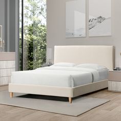 a white bed sitting on top of a wooden floor