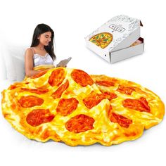 a woman sitting in front of a giant pizza shaped like a pie with pepperoni on it