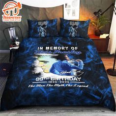 a bed covered in blue and black comforter with an image of a man on it