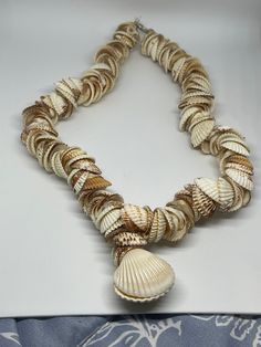 a necklace made out of seashells on a white surface