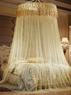 a bed with a white canopy over it in a room next to a dresser and lamp