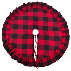 a red and black plaid pillow with ruffles on the bottom, sitting in front of a white background