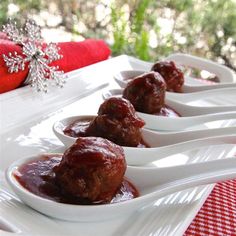 meatballs with sauce in small white dishes on a red and white tableclothed cloth