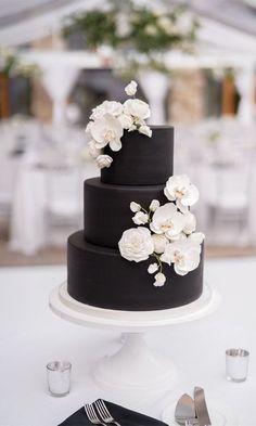 a black and white wedding cake with flowers on top