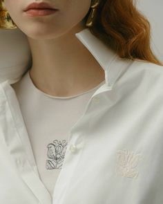 This Long Sleeve Shirt with Iris Embroidery is the perfect wardrobe addition. Expertly designed with a classic silhouette, this shirt has an intricate Iris embroidery detail for an instantly elevated aesthetic. Perfect for everyday wear, the astonishing details of this shirt will make it the center of attention.AW23/24 Handmade in Latvia Fabric origin - Italy Iris embroidery Models height: 180 cmModel is wearing a size S Embroidered Spread Collar Top For Work, White Floral Embroidered Shirt For Work, Elegant Cotton Shirt With Floral Embroidery, Elegant Embroidered Short Sleeve Shirt, Elegant Short Sleeve Embroidered Shirt, Elegant Blouse With Floral Embroidery And Relaxed Fit, Classic Embroidered Button-up Shirt, Classic Embroidered Short Sleeve Shirt, White Shirt With Floral Embroidery And Spread Collar