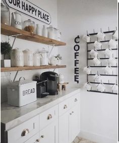 a kitchen with white cabinets and open shelving above the counter is decorated with coffee mugs