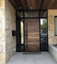 the front entrance to a home with stone walls and wood ceilinging, along with a planter filled with succulents