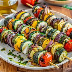 a white plate topped with lots of veggies on skewers