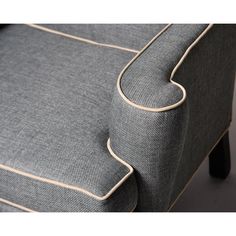 the back end of a gray chair with beige piping