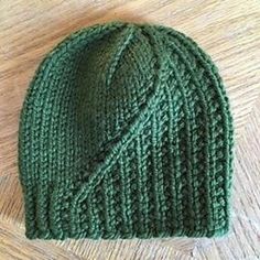 a green knitted hat sitting on top of a wooden floor