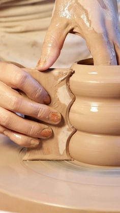 a person is making clay on a potter's wheel with their hands and fingers