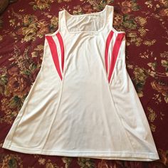 a women's white and red tank top laying on a bed with floral sheets