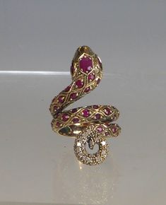 A stunning 9ct solid gold real ruby & diamond coiled snake ring the front of the coiled snake is fully set with quality round cut rubies with a larger oval cut ruby to head. the tip of tail is set with 32 real round cut diamonds. the double back band is designed with snake scales engraved in the gold. front measures 3.5cm high, sits around finger & very comfortable to wear. ring size uk-n, usa6.75. stamped 9ct. looks stunning when worn. box for display only will come boxed. Snake Gold Ring, Snake Engagement Ring, Snake Jewellery, Snake Scales, Coiled Snake, Snake Jewelry, Snake Ring, Gold Snake, Ruby Diamond