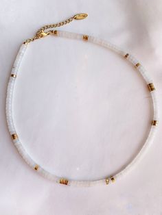 * White jade gemstones * hematite pearls gilded with fine gold 24k * Stainless steel carabiner clasp * Collar mounted on a resistant wire * Size: 35 cm + 5 cm extension chain ◊ Necklace entirely handmade, delivered in its small pouch ◊ Manufacturing times: 2 to 5 days Minimalist White Gemstone Beaded Necklaces, White Minimalist Beaded Gemstone Necklace, Adjustable White Beaded Necklace With Natural Stones, White Heishi Beads Necklace With Spacer Beads, White Heishi Beads Single Strand Jewelry, Handmade White Heishi Beads Jewelry, White Heishi Beads Jewelry For Gift, White Gold Cross Pendant, Chic Gifts