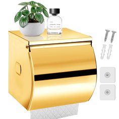 a gold toilet paper dispenser with a potted plant on top