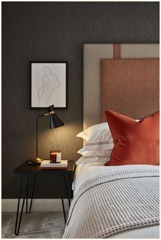 a bedroom with a bed, nightstand and pictures on the wall above it's headboard