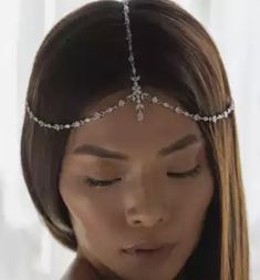 a woman with long hair wearing a head chain